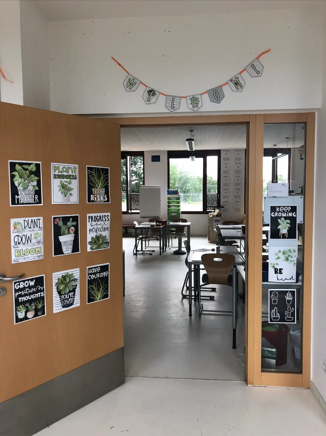 Setting up the classroom is an important part of the back-to-school teacher checklist. The front door of the author's classroom with encouraging posters and welcome sign at the top.
