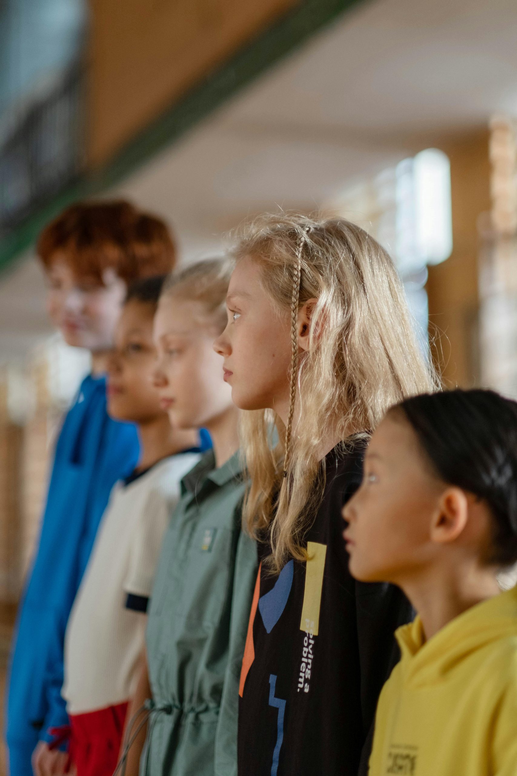 A line of elementary students standing quietly in a school hallway, practicing how to line up and walk calmly.
