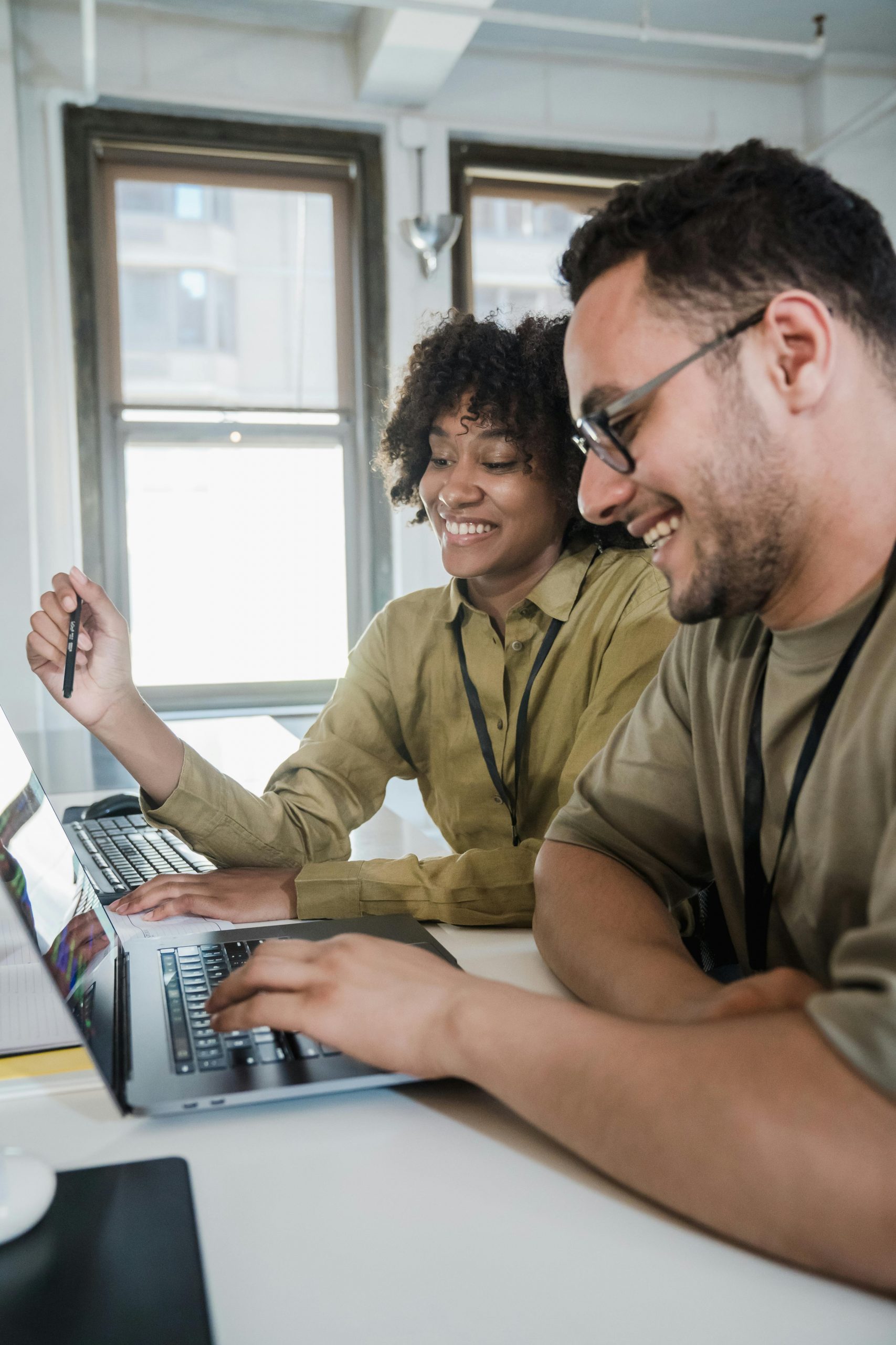 Two teachers collaborating at computers—finding a mentor is one of the most valuable new teacher tips for your first year of teaching.