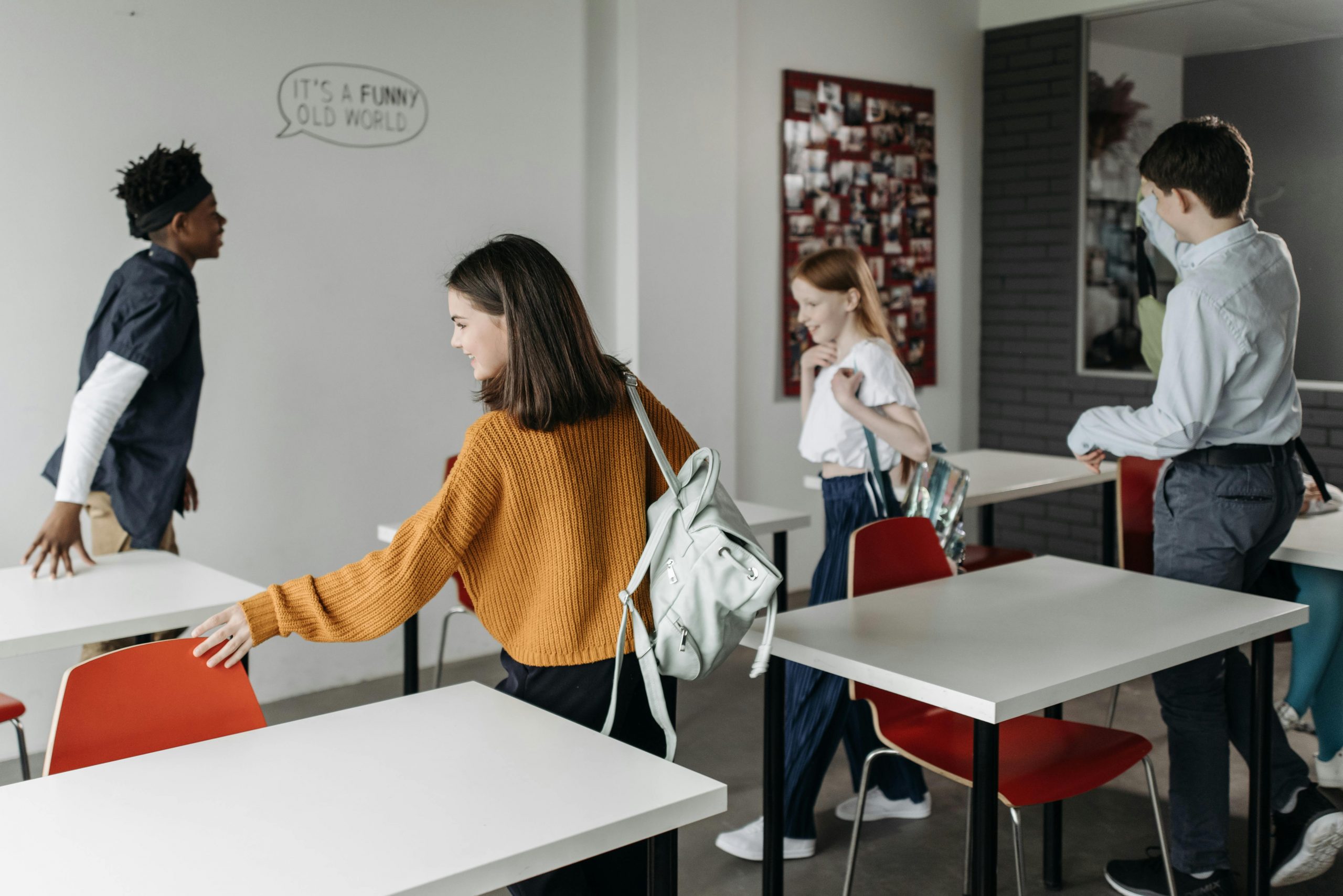 Students pushing in chairs and grabbing their backpacks at the end of the school day, following a calm and organized routine.